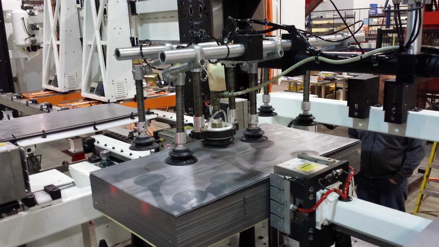 An image of a Linear Automation pick-and-place blank feeder, picking up flat metal blanks using vacuum technology.