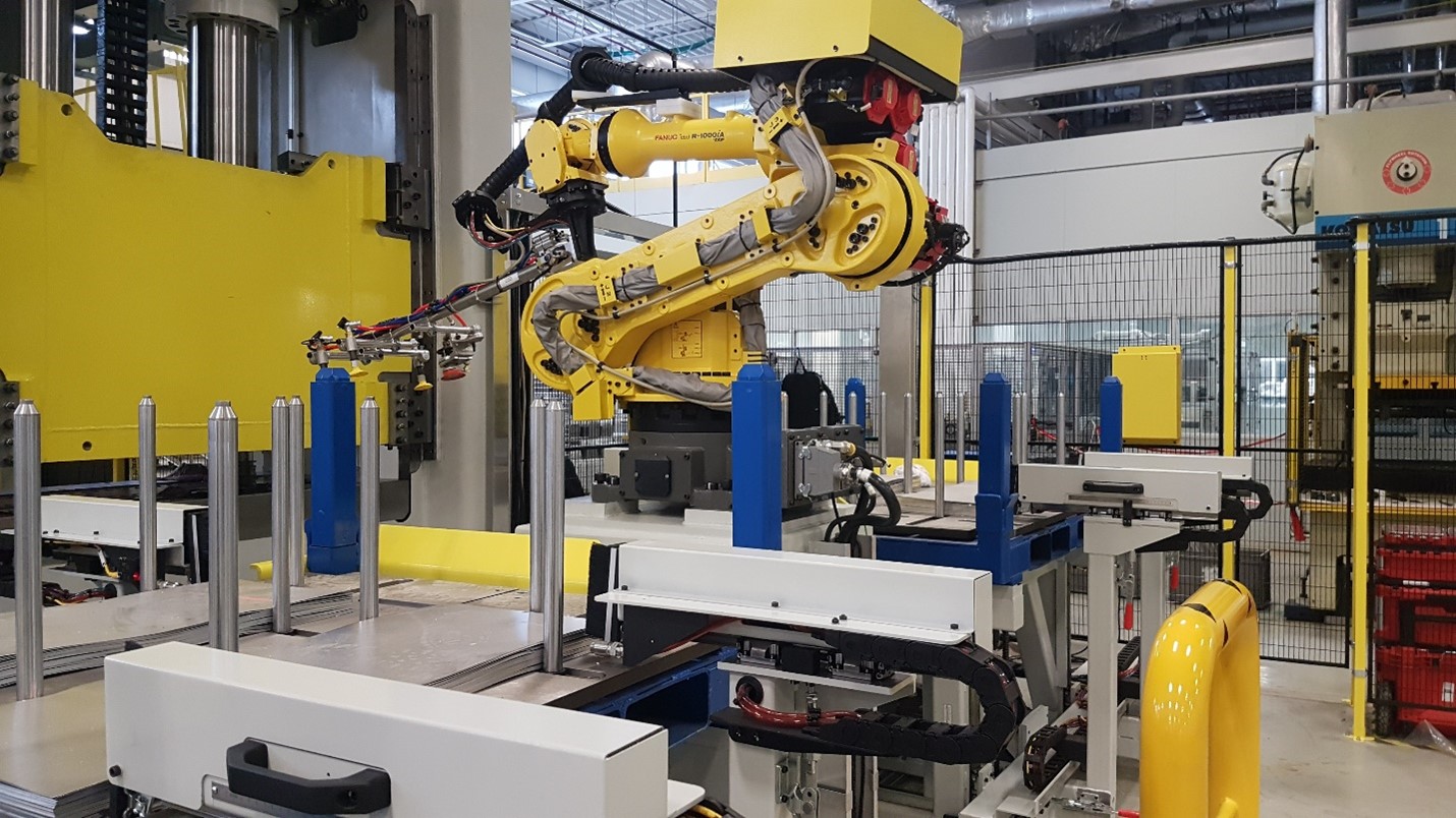 Linear Automation robotic press-to-press cell with yellow FANUC robots.