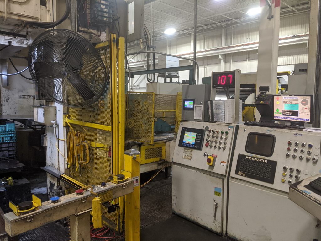 An image of an outdated control module next to a large stamping press before it is outfitted with a Linear FR transfer system.